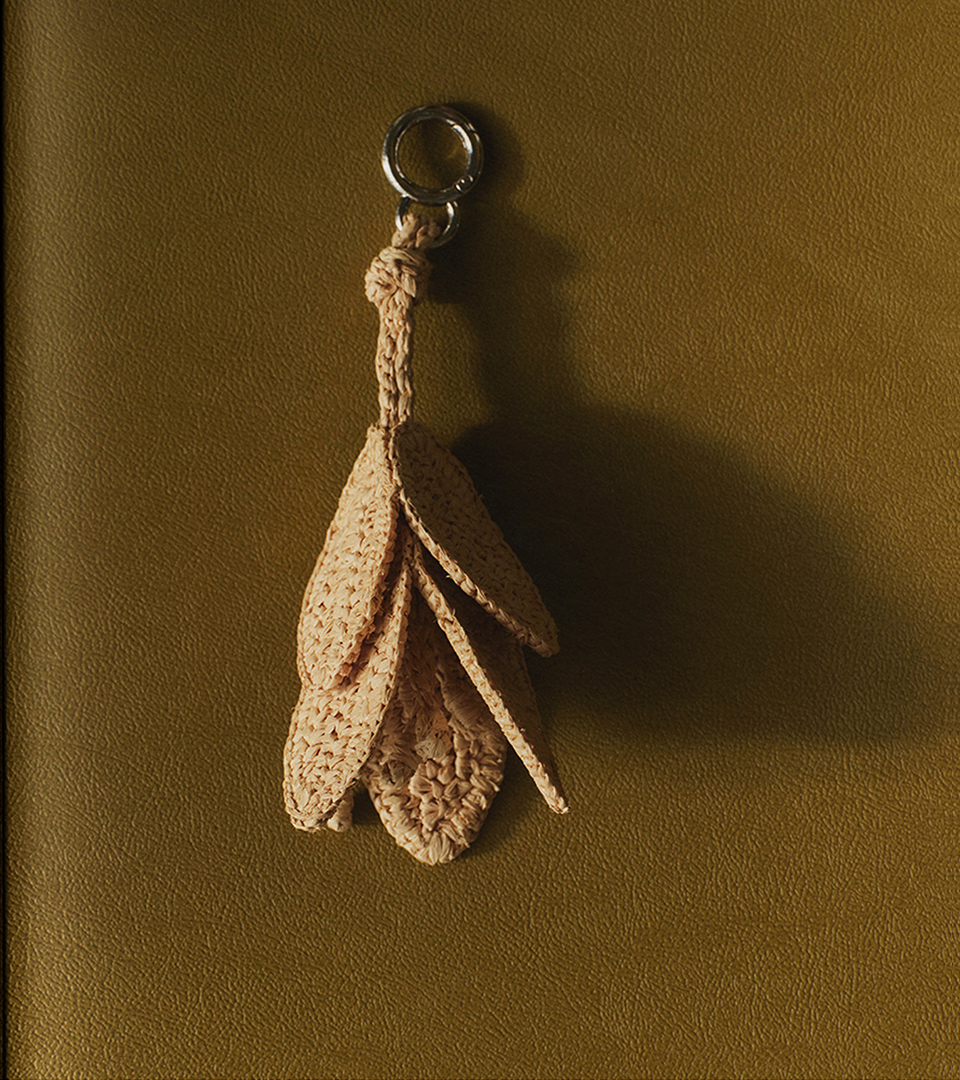 Crochet pendant key ring in an ecru tone on an olive-green background