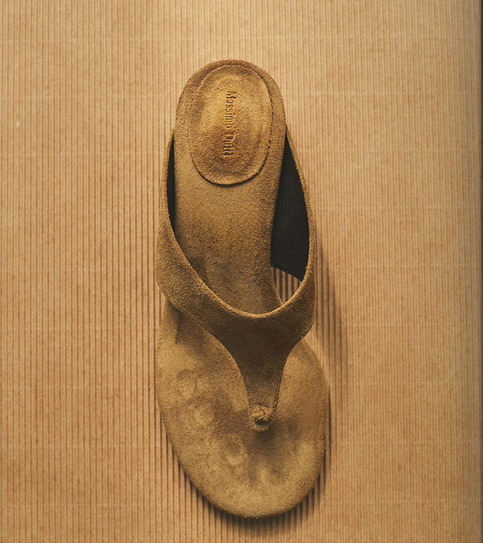 Natural-toned leather toe-post sandal on a cardboard background