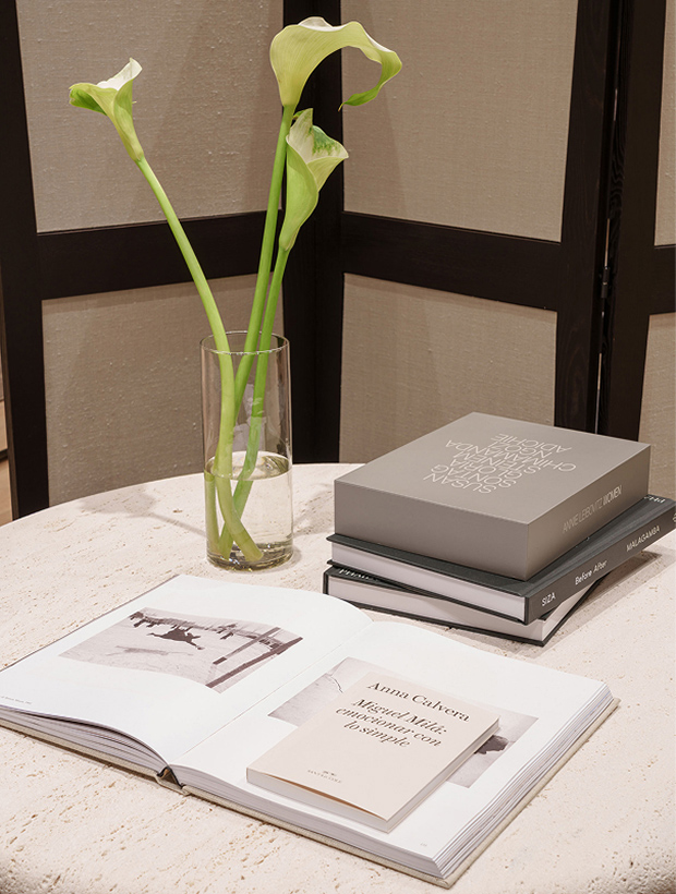 Apartamento editorial detail at Massimo Dutti Mallorca with books, flowers and stone table
