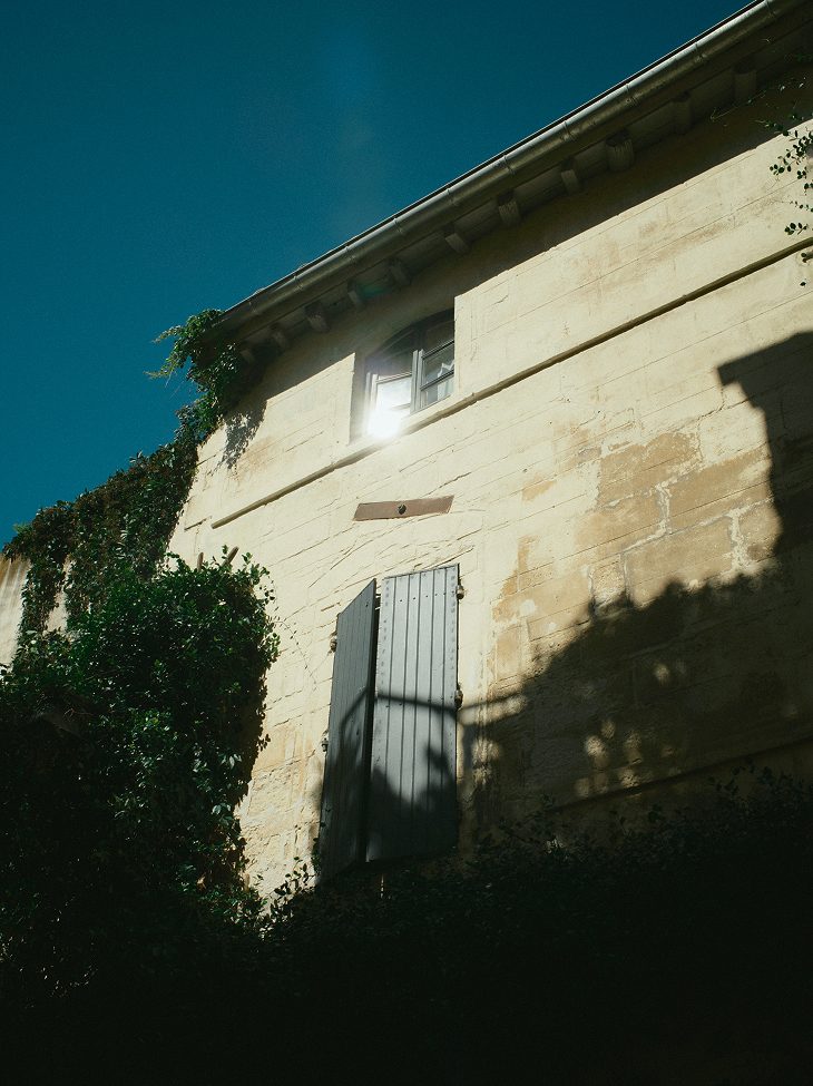 Corner of a stone building covered in ivy at sunset — Arles