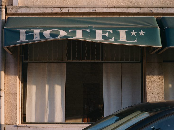 Hotel sign and awning on a street in Arles
