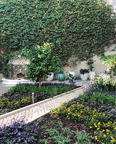 Garden with flowerbeds and Portuguese calçada paving, designed by Jesús Moraime — Massimo Dutti Lisbon