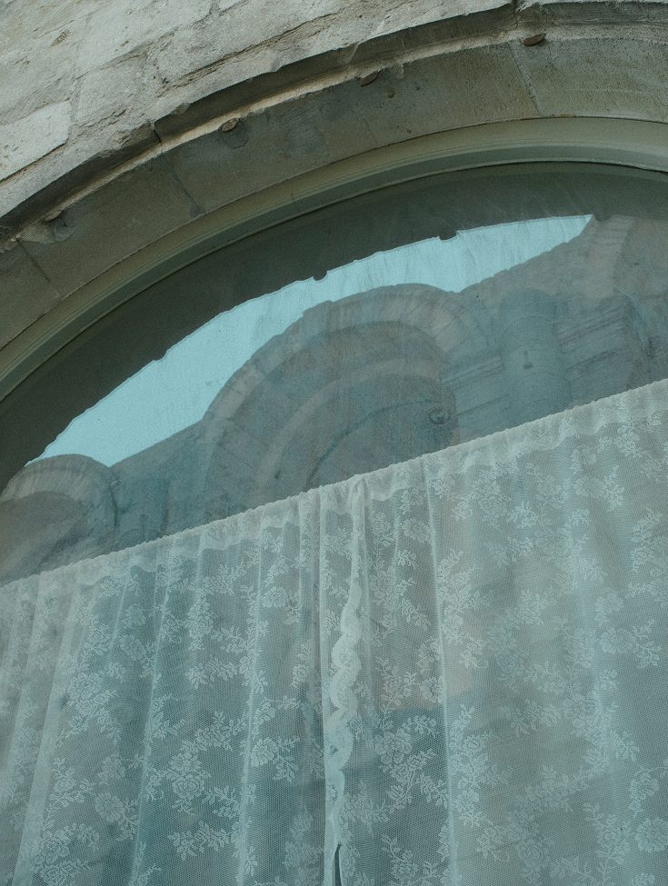 Stone arch with a turquoise curtain — Arles