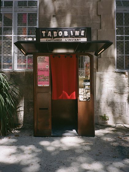 Tabobine photo booth with a red curtain on a façade — Arles