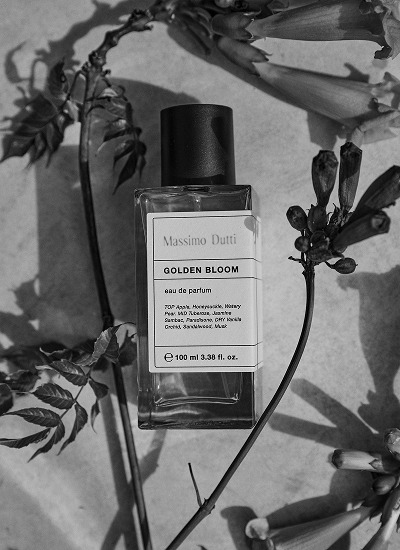 Golden Bloom eau de parfum bottle among foliage, in black and white — Massimo Dutti