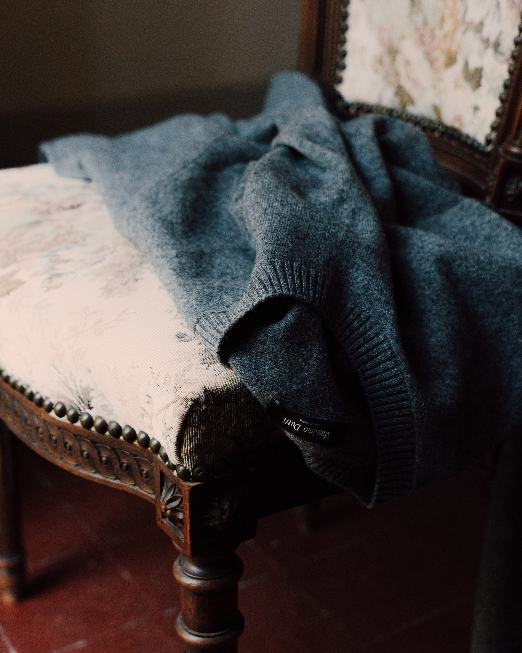 Grey cashmere sweater on an antique upholstered chair — Massimo Dutti Fall Treasures