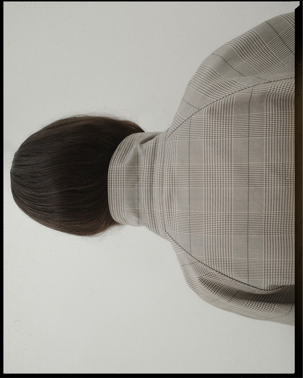Model from behind in a checked high-neck jacket, with black frame — Massimo Dutti