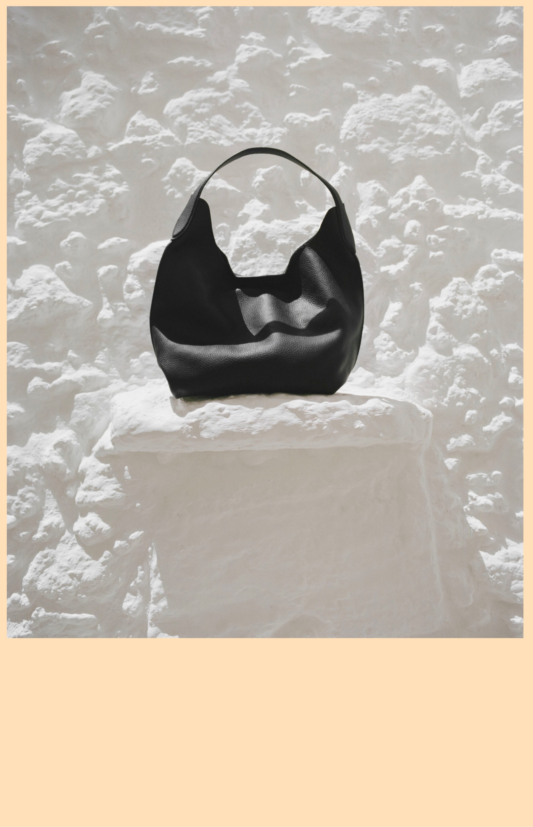 Black nappa mini shoulder bag on a white stone block — Massimo Dutti