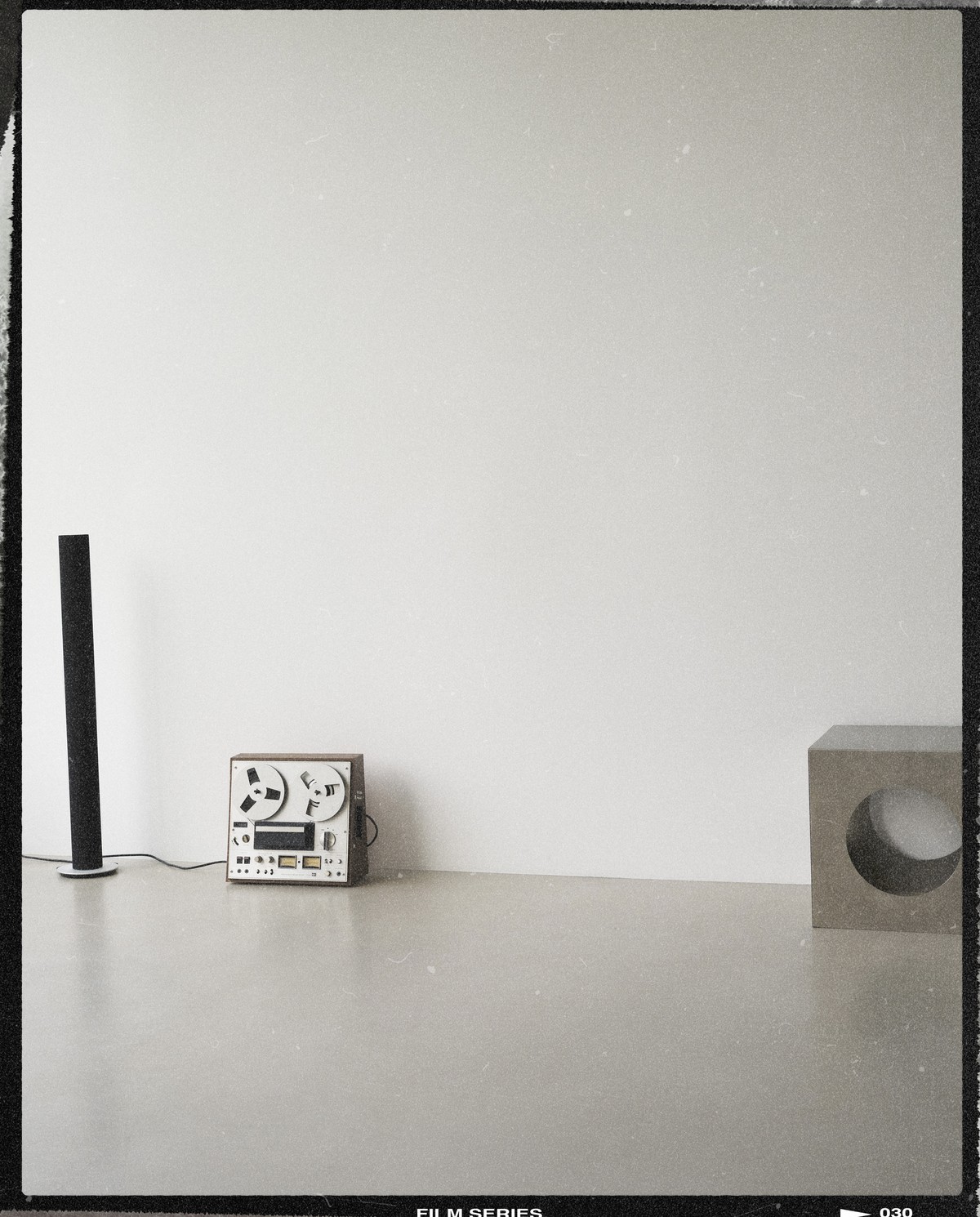 Set design by Giovanna Martial on a film frame: reel-to-reel recorder, speaker and concrete cube — Massimo Dutti