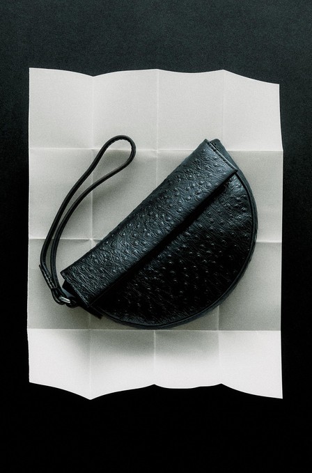 Black textured nappa leather half-moon bag on white paper — Massimo Dutti Puffer Jackets
