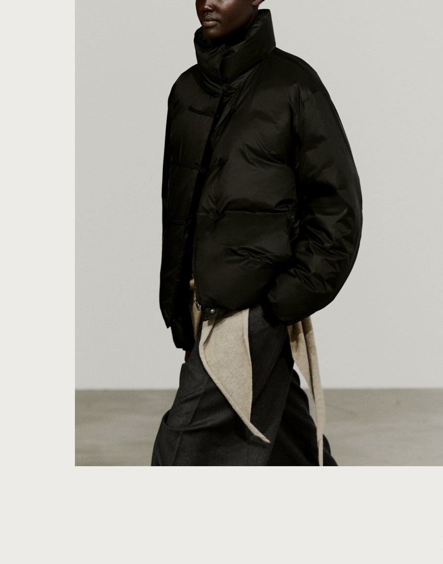 Woman wearing a black high-collar puffer jacket with toggle fastenings — Massimo Dutti Puffer Jackets