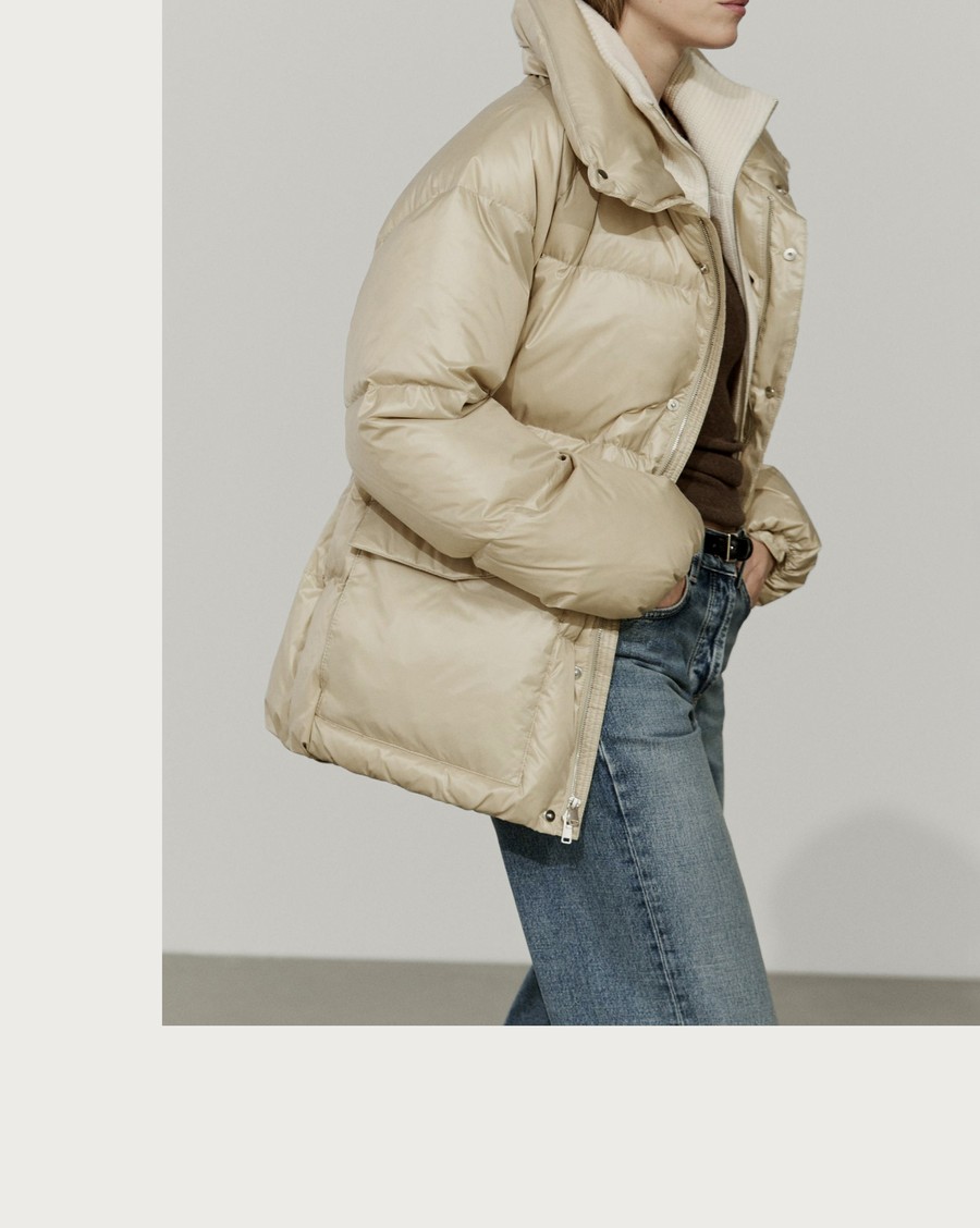 Woman wearing an ivory high-collar puffer jacket and jeans — Massimo Dutti Puffer Jackets
