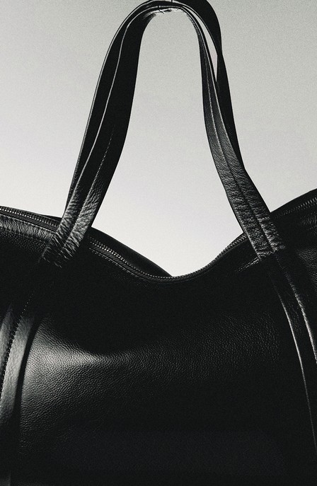 Handles of a black leather carry-on bag — Massimo Dutti Puffer Jackets