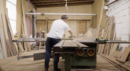 Igor Polasiak cutting wood on the saw in his studio