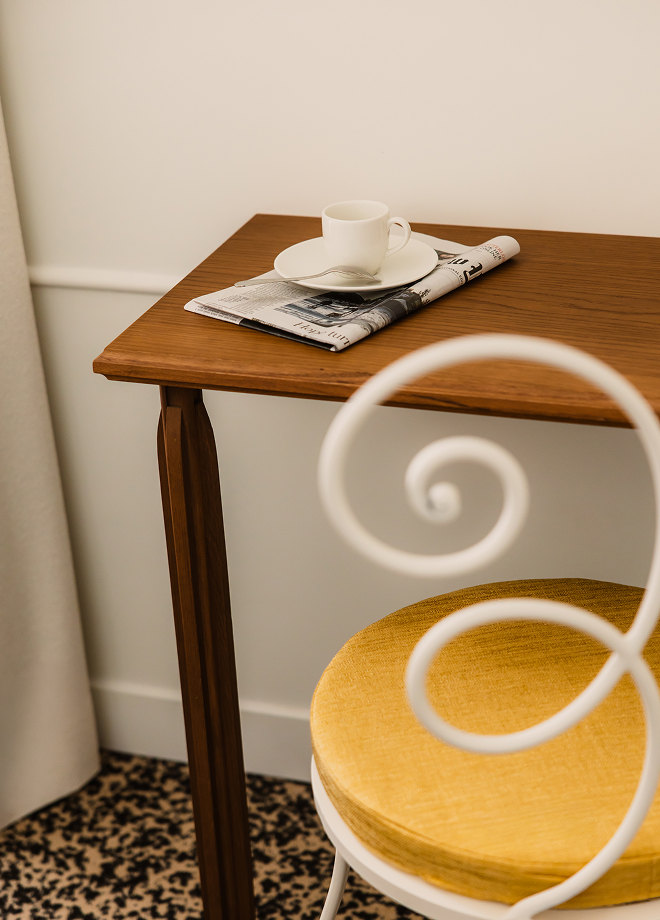 Table and wrought-iron chair in a room at Hôtel Blanca — Massimo Dutti Paris Fashion Week