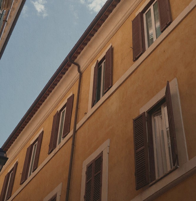 Ochre façade with windows and shutters in Rome