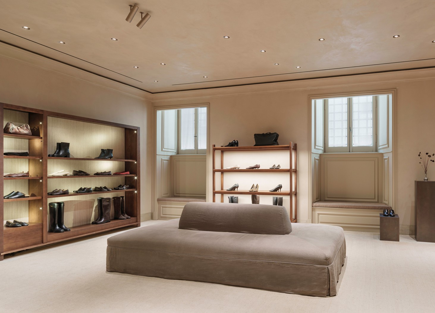 Footwear room with wooden shelving, an upholstered bench and windows — Massimo Dutti Rome