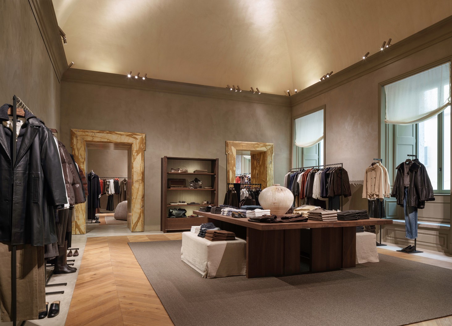 Womenswear room with clothing rails, a central table and poufs — Massimo Dutti Rome