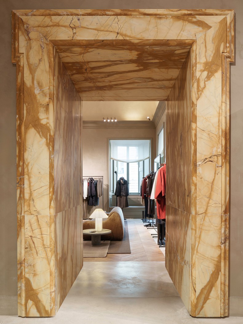 View through the marble doorframe into the womenswear room — Massimo Dutti Rome