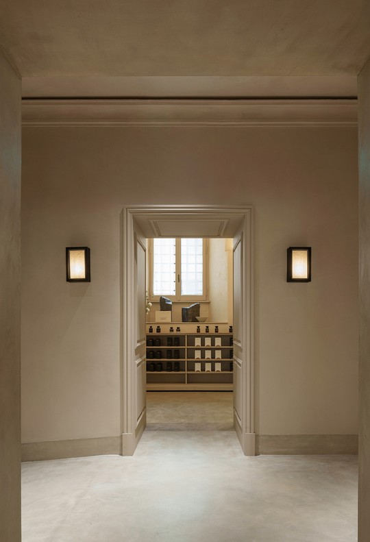 Entrance to The Perfumes Room through an opening with wall lights — Massimo Dutti Rome