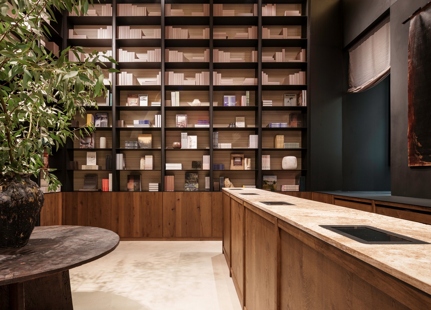 Bookshop shelves with books and objects and a wooden counter — Massimo Dutti Rome