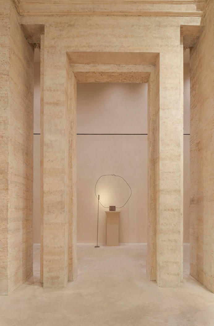 Travertine opening with a pedestal and a wire sculpture — Massimo Dutti Rome