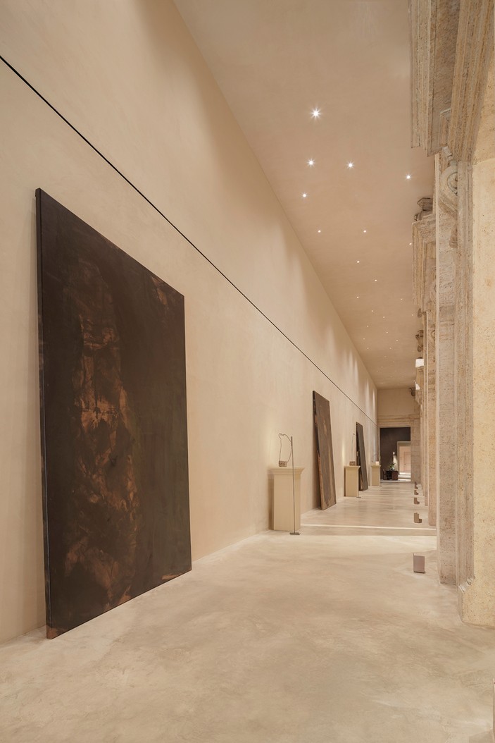 Travertine corridor with a large dark canvas — Massimo Dutti Rome
